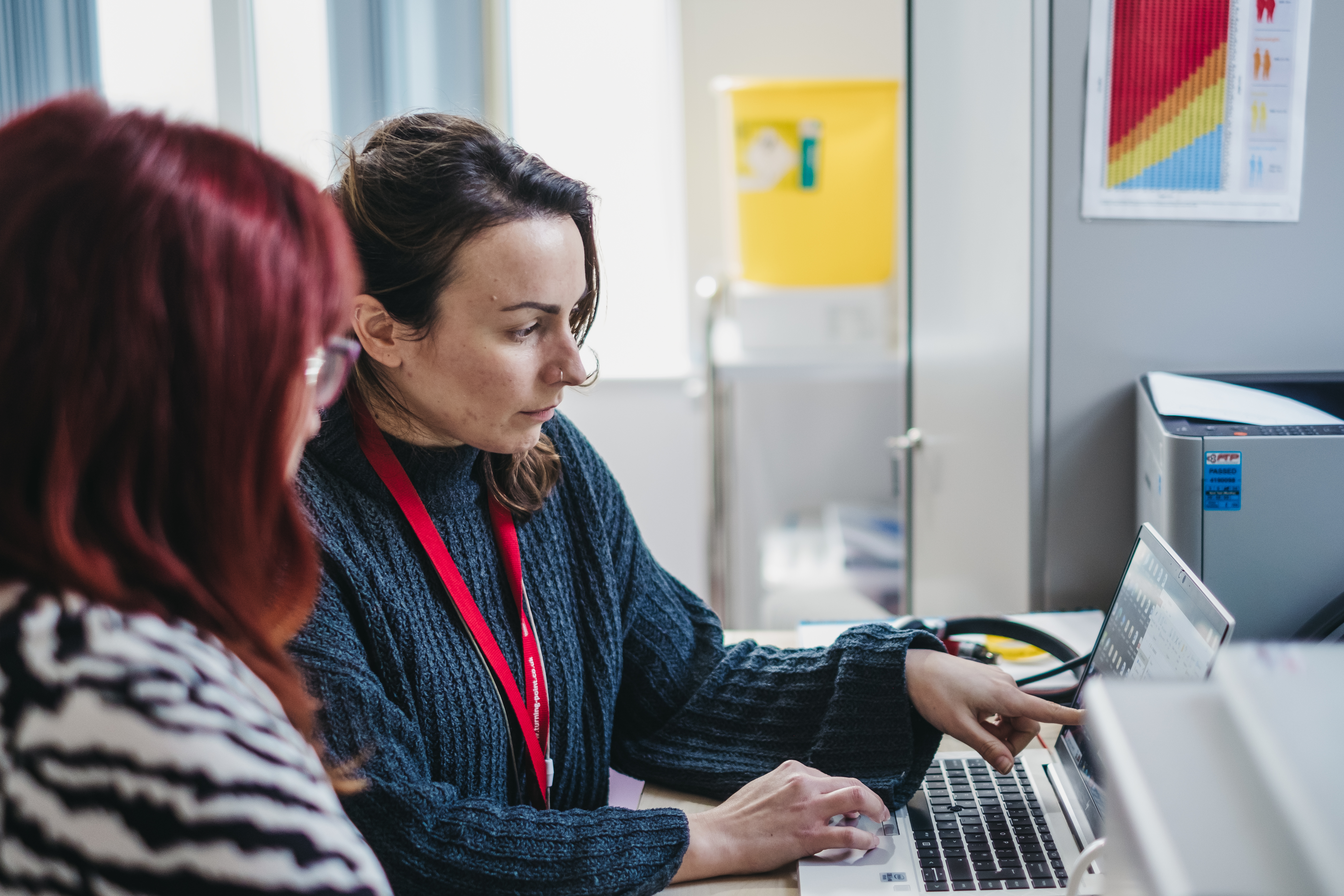 Two women at a desk looking at a laptop