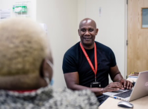 A person sitting at a computer talking to someone else